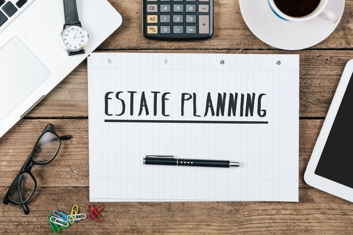 Stock photograph: an Estate Planning document with a pen and glasses on a wooden desk
